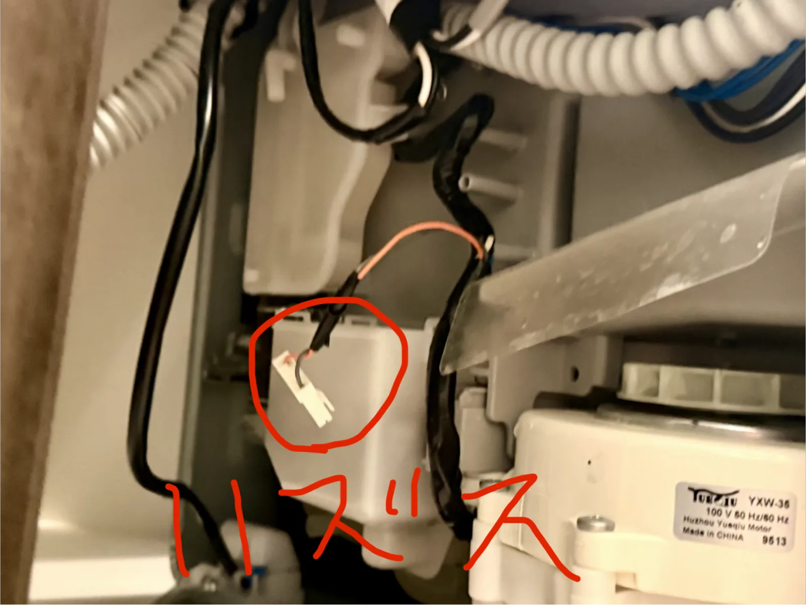 赤丸で囲まれた白い2極のカプラー。すぐ右に排水ポンプのモーター（YXW-35、100V 50/60Hz）が並んでいる