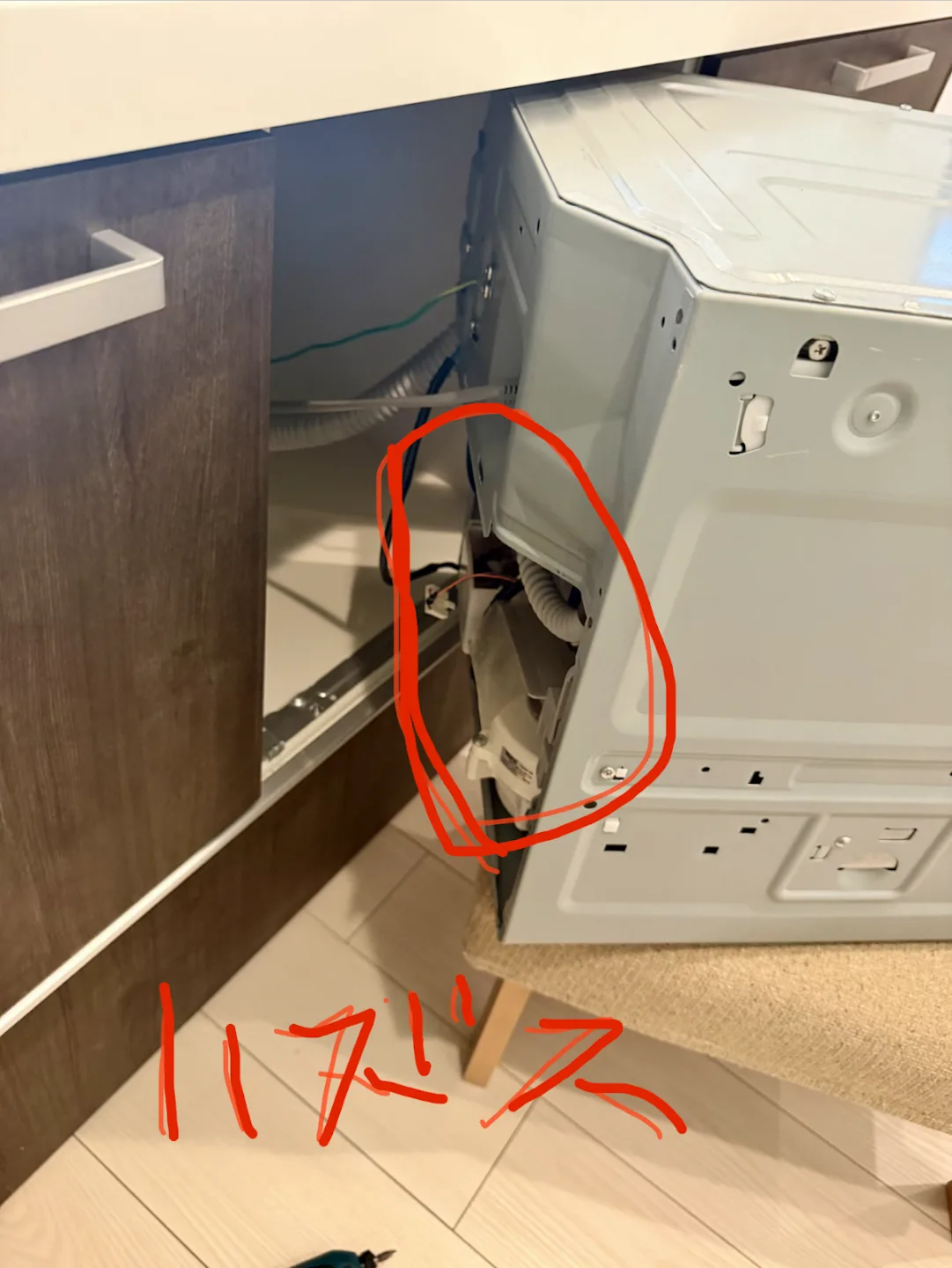 キャビネットから半分引き出した食洗機ユニットを左後ろから見た写真。カプラーの位置が赤丸で囲まれ、「ハズス」と赤字で書き込まれている